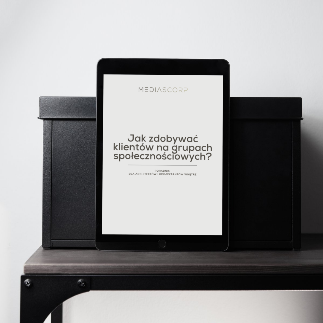 Tablet z e-bookiem o pozyskiwaniu klientów dla architektów i projektantów wnętrz leżący na półce między czarnymi pudełkami